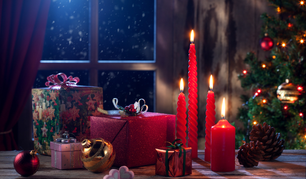 Зажженные красные свечи с подарками и игрушками на Новый год 2018