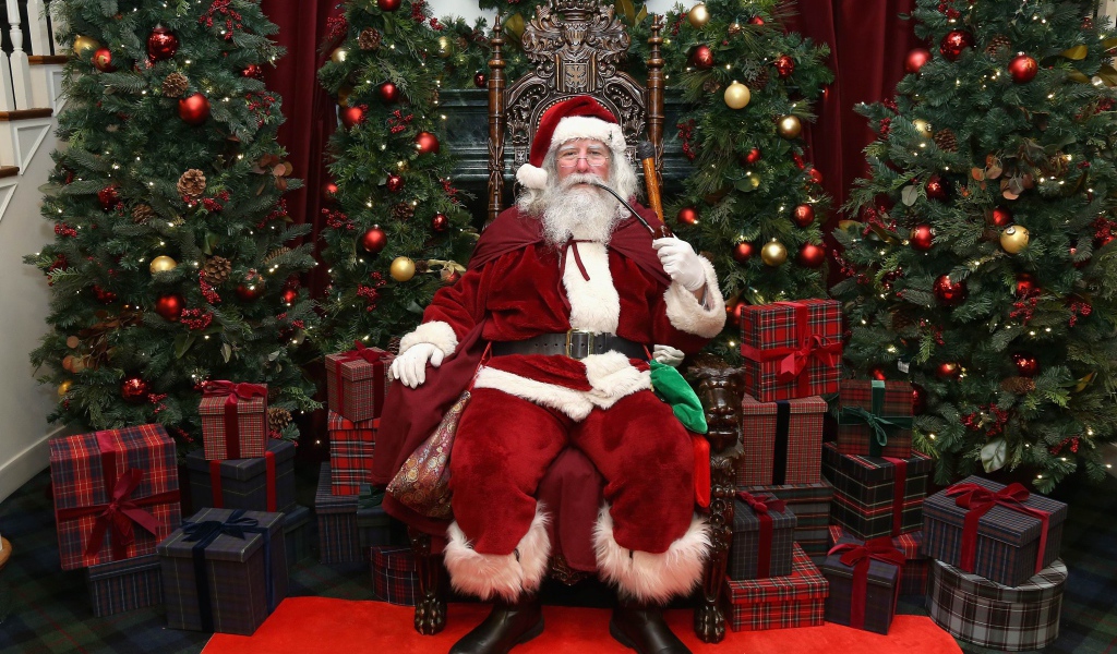 Санта Клаус курит трубку сидя в кресле