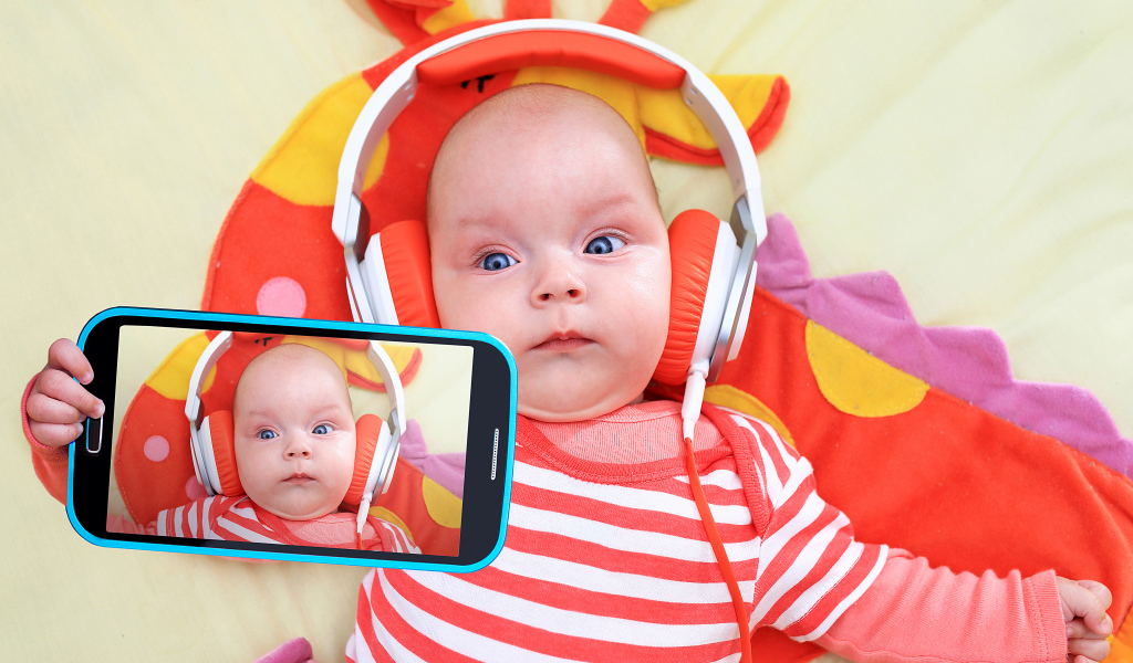 Младенец в оранжевых наушниках делает селфи