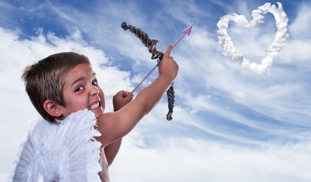 Мальчик в костюме купидона пускает стрелу в небо