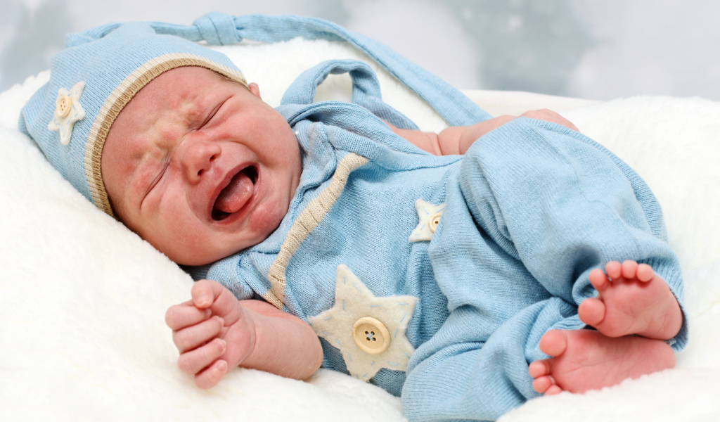 Плачущий младенец в голубом костюме