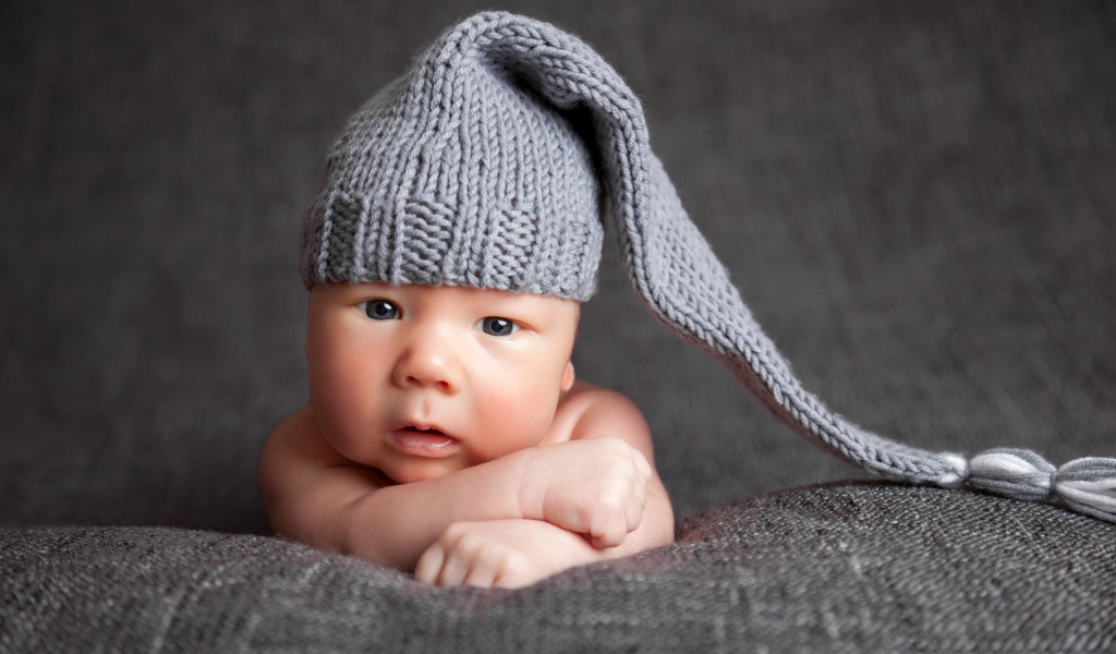 Милый младенец в большой серой вязаной шапке