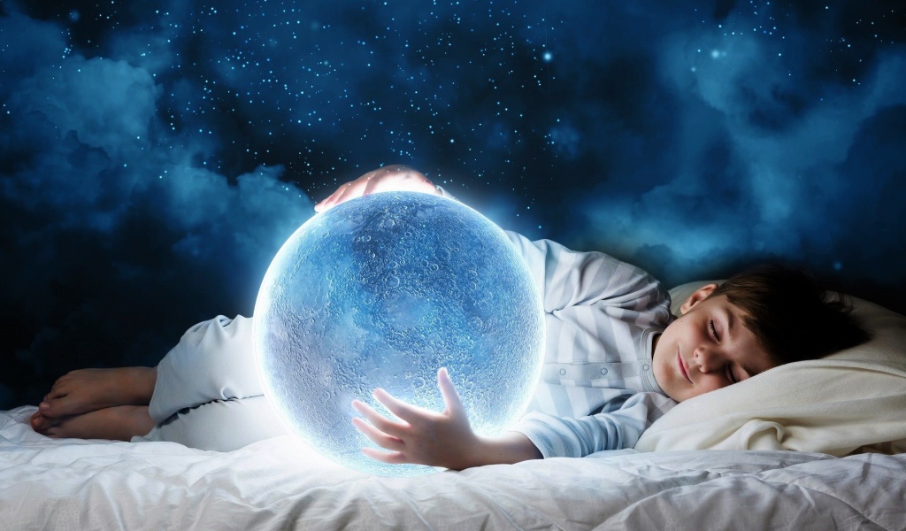Маленький мальчик во сне держит в руках волшебную голубую луну