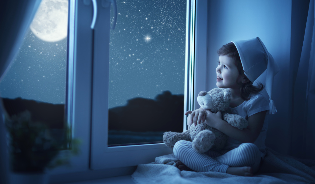 Маленькая девочка сидит на подоконнике с игрушкой ночью