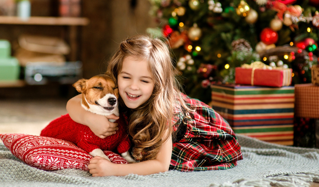 Маленькая девочка с собакой радуются новому году