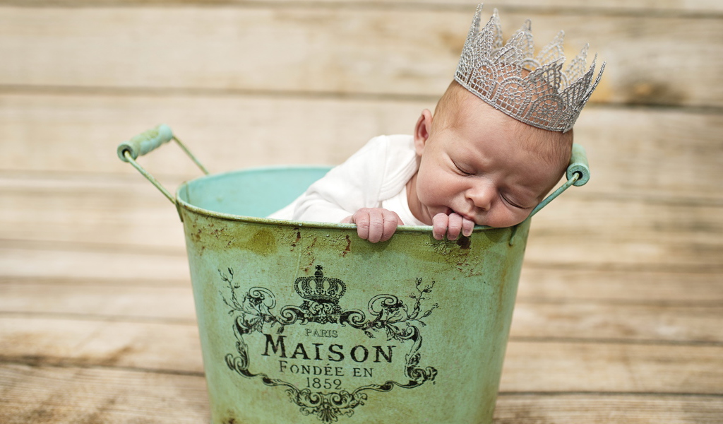 Спящий грудной ребенок с короной на голове