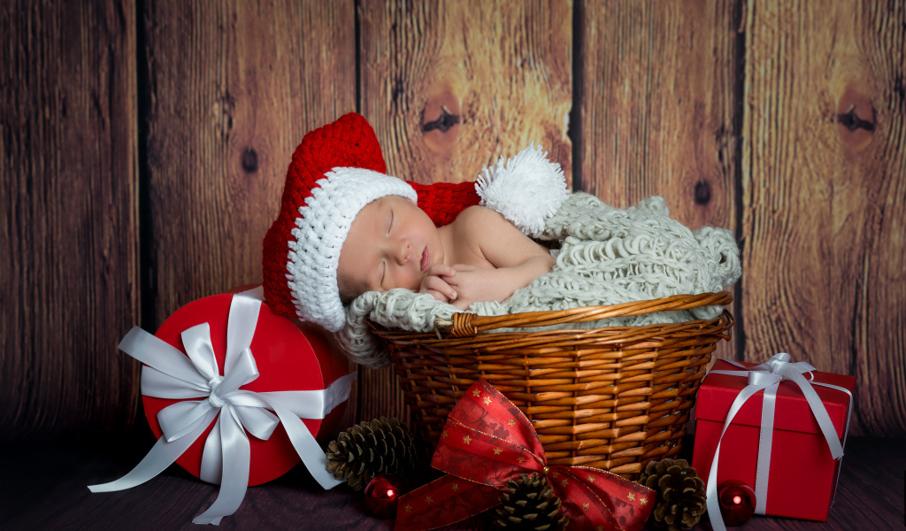 Маленький грудной ребенок спит в плетеной корзине с новогодними подарками