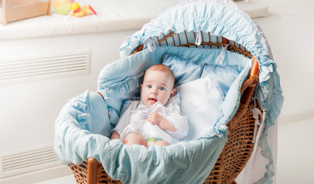 Маленький голубоглазый младенец в кроватке