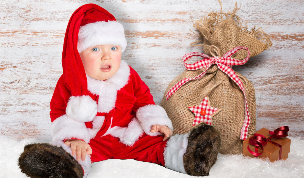 Маленький ребенок в костюме Санты с мешком