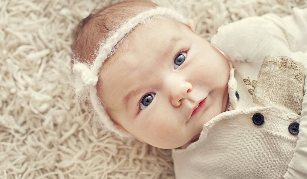 Красивая голубоглазая малышка с повязкой на голове