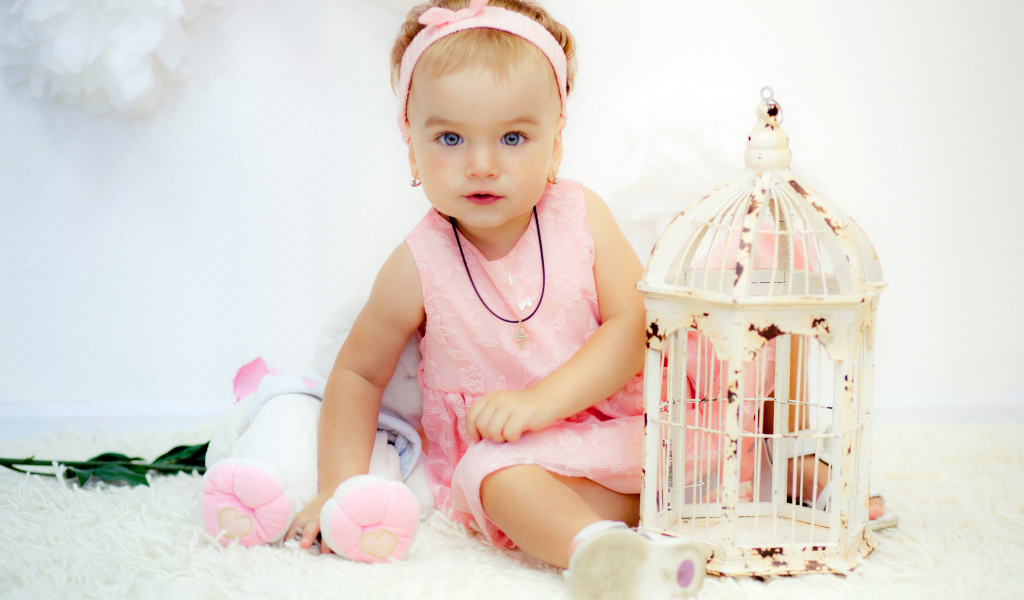 Красивая маленькая девочка в розовом платье с клеткой