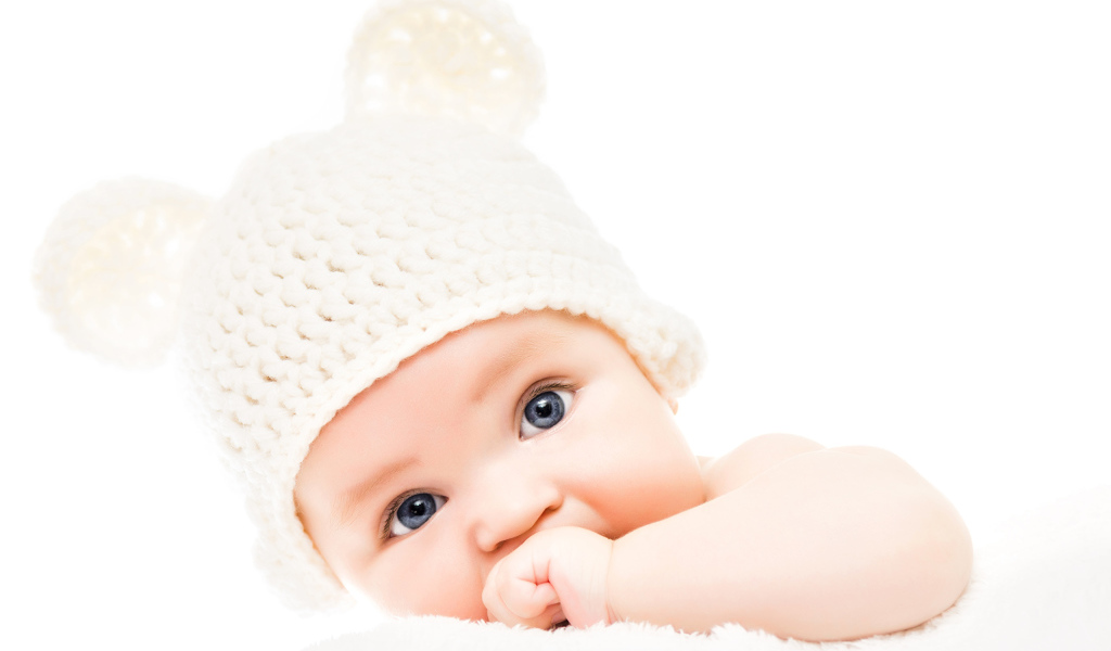 Голубоглазый младенец с белой шапке с ушками на белом фоне