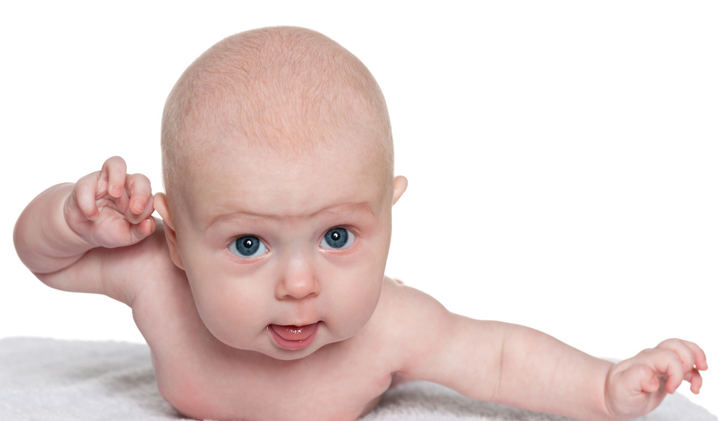 Голубоглазый малыш лежит на белом фоне