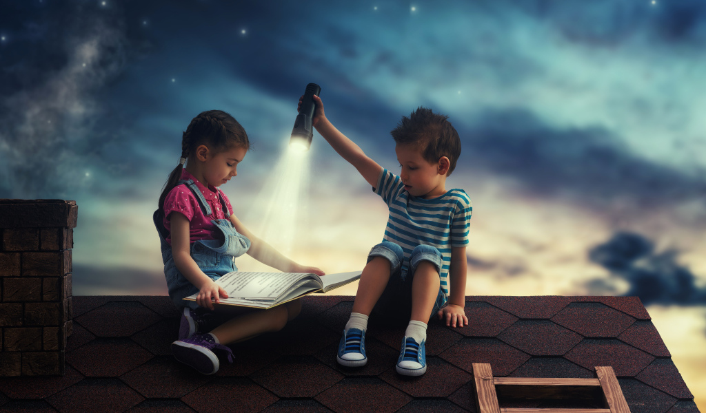 Мальчик и девочка ночью читают книгу на крыше