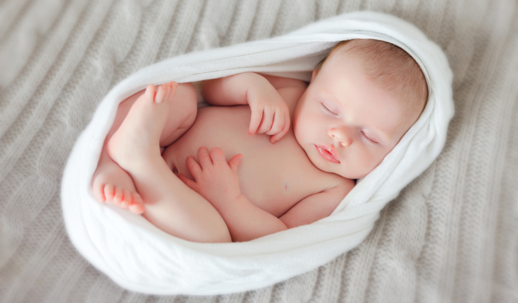 Милый спящий младенец в белом покрывале