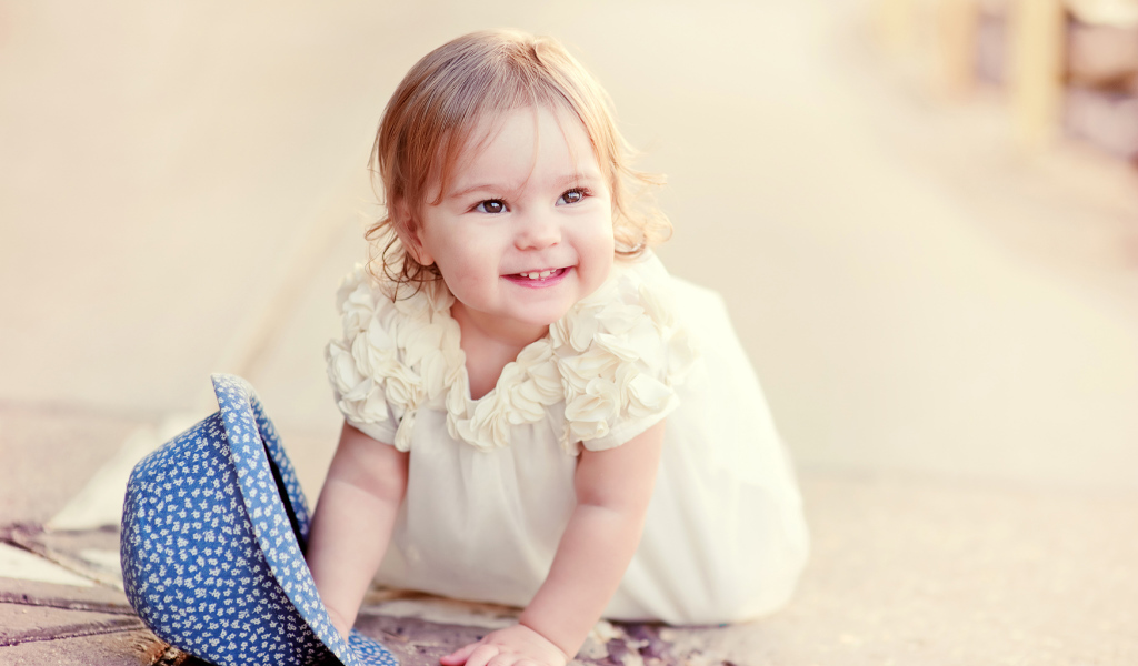 Милая улыбающаяся девочка в белом платье