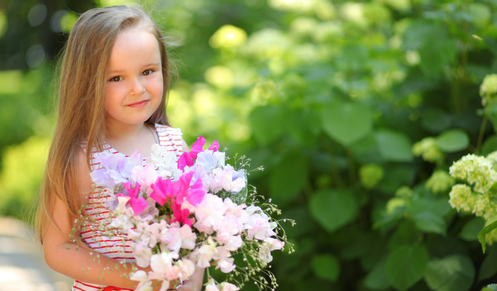 Русоволосая девочка с букетом цветов в руках