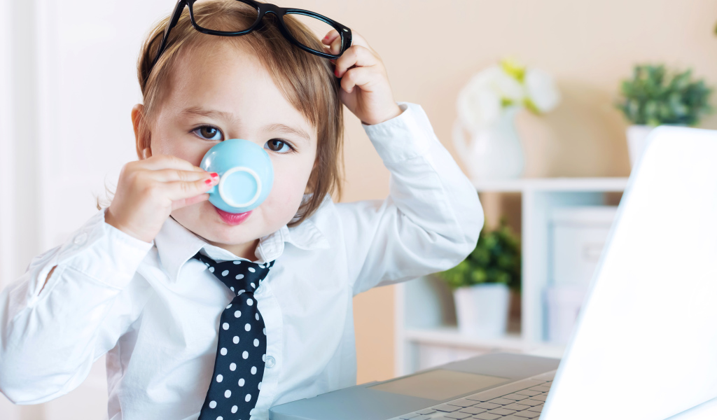 Маленький мальчик в деловом костюме и с чашкой