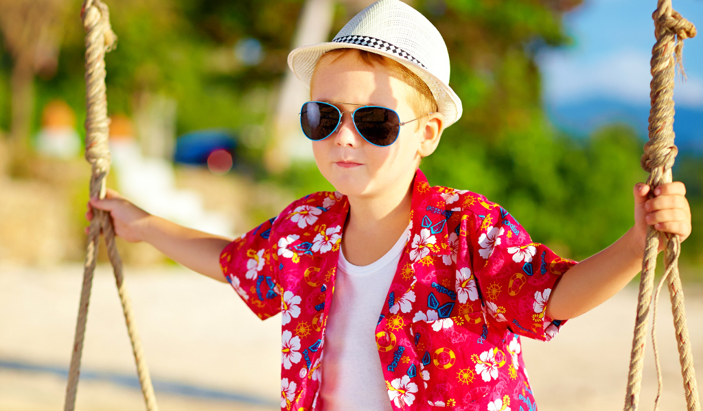 Маленький мальчик в белой шляпе и солнечных очках