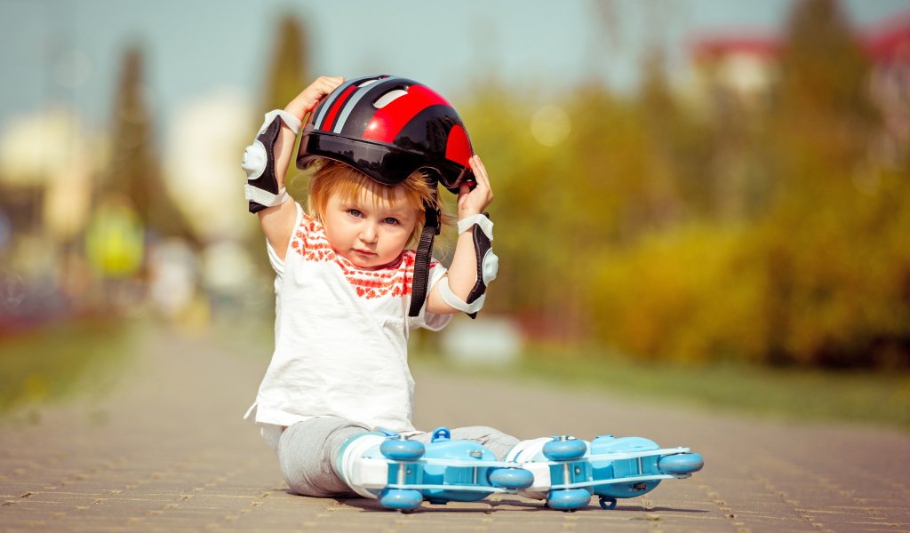 Маленький мальчик в шлеме и роликовых коньках