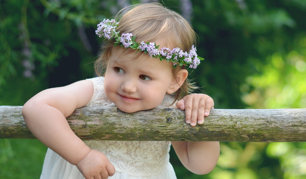 Маленькая кареглазая девочка с венком на голове