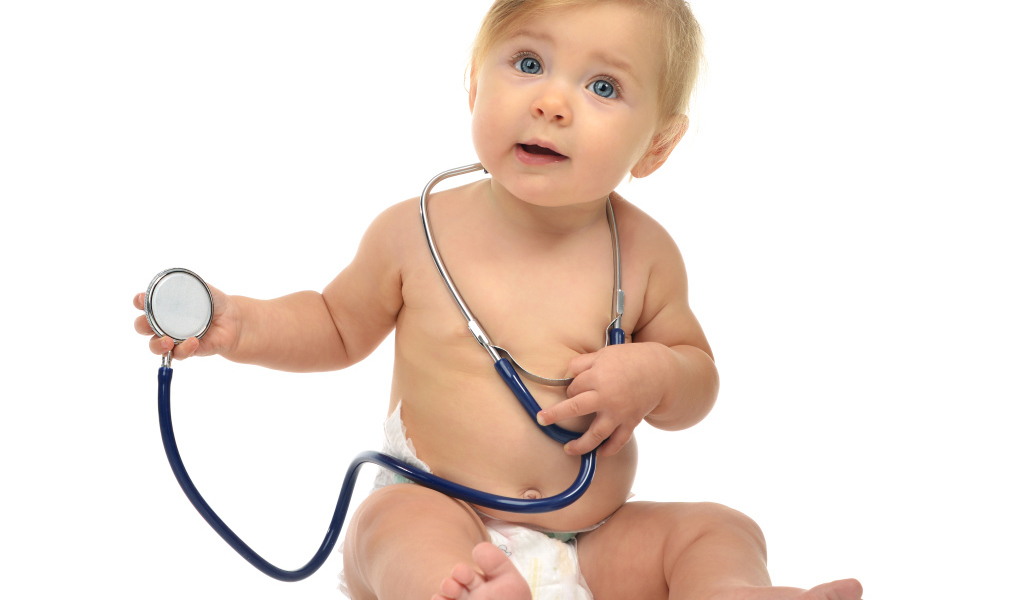 Маленький ребенок со стетоскопом на белом фоне