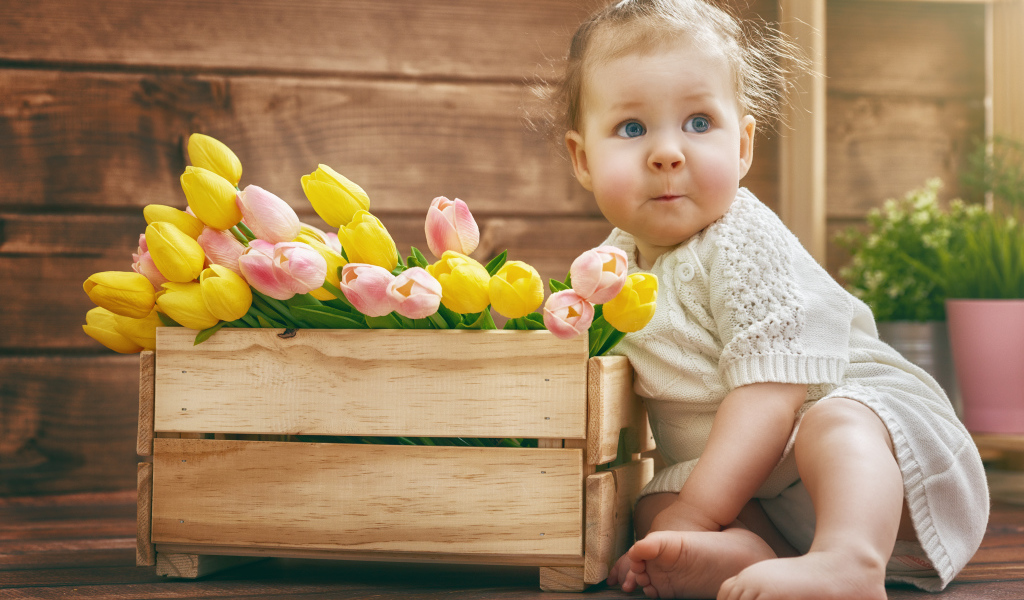 Маленькая забавная девочка с букетом тюльпанов