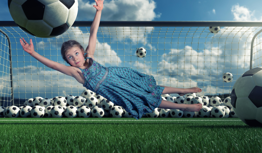 Маленькая девочка вратарь ловит мяч в воротах