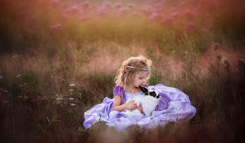 Маленькая девочка в красивом платье с кроликом в руках