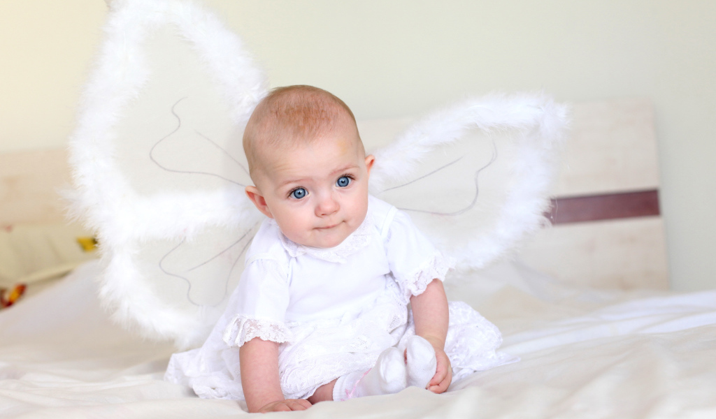 Маленькая девочка в красивом белом платье с крыльями