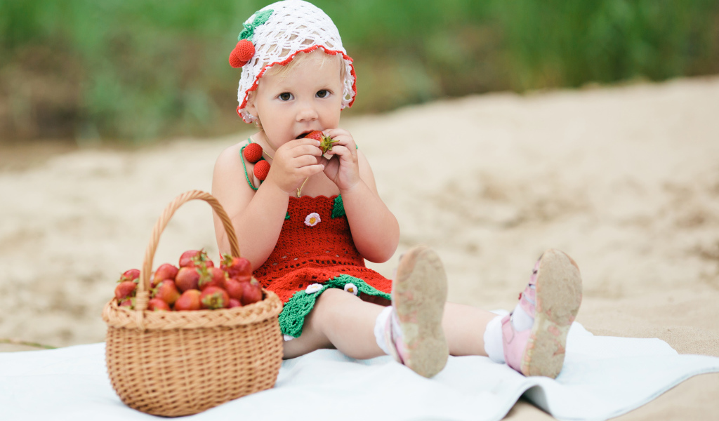 Маленькая девочка в большой корзиной клубники