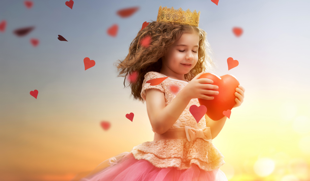 Маленькая девочка в костюме принцессы с красным сердцем в руках
