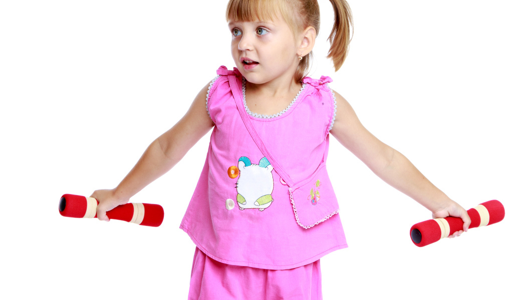 Маленькая девочка в розовом костюме с гантелями в руках