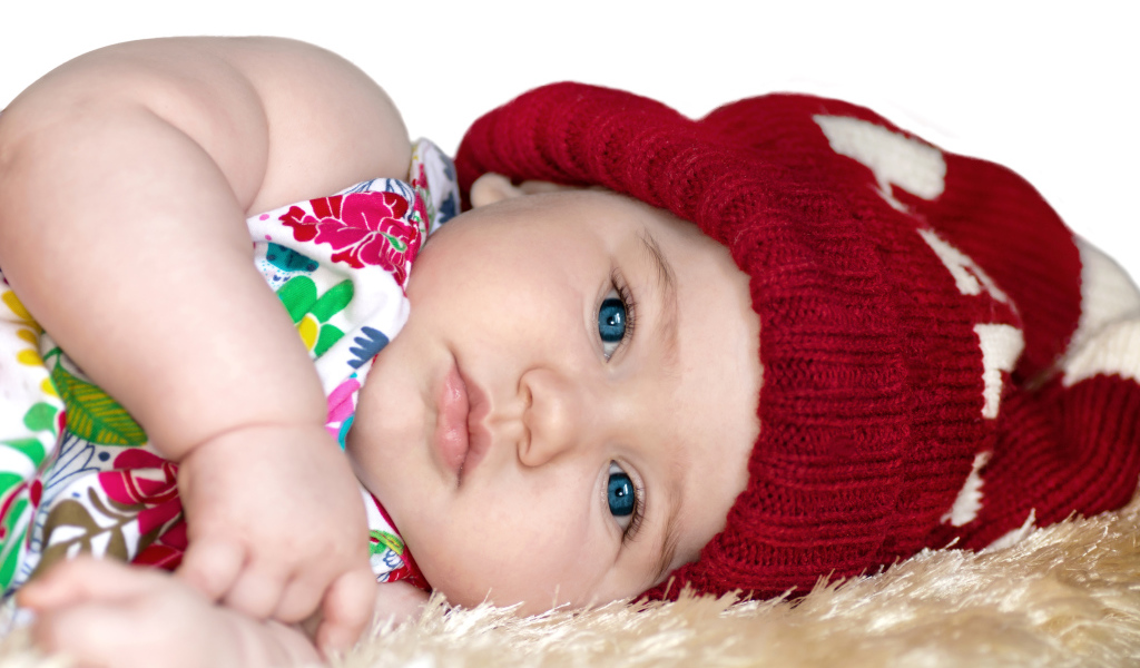 Маленькая девочка в красной вязаной шапке