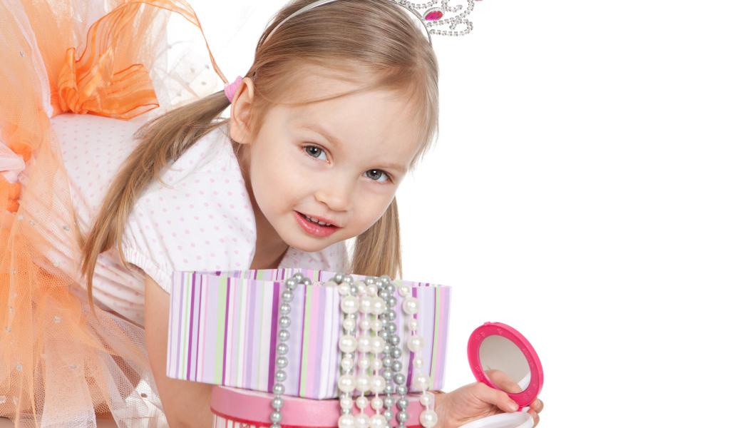 Маленькая девочка в короне на голове и с зеркалом на белом фоне