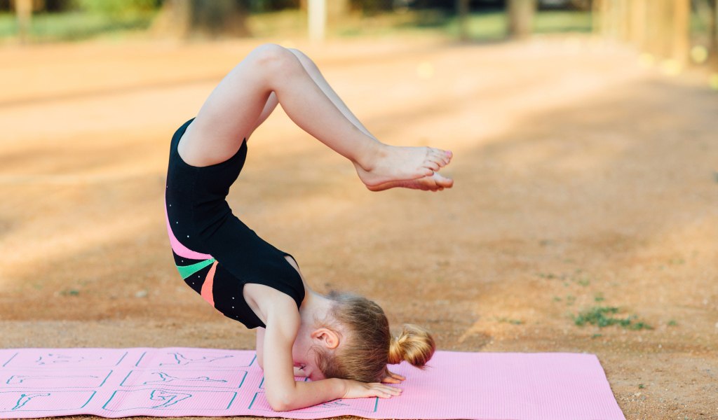 Маленькая девочка занимается гимнастикой