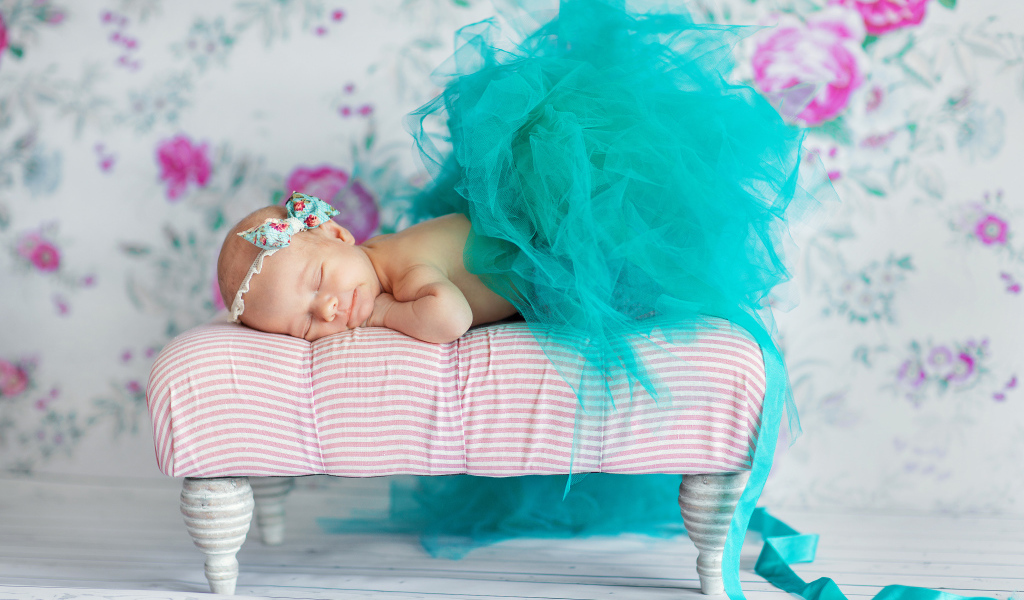 Маленькая девочка спит в красивом бирюзовом платье