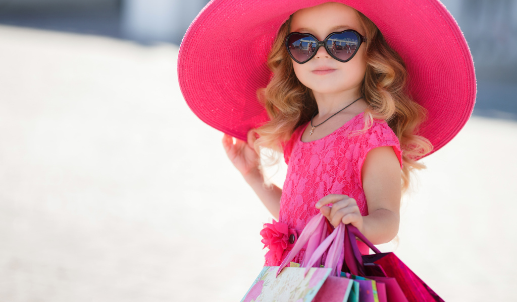 Маленькая девочка модница в большой розовой шляпе