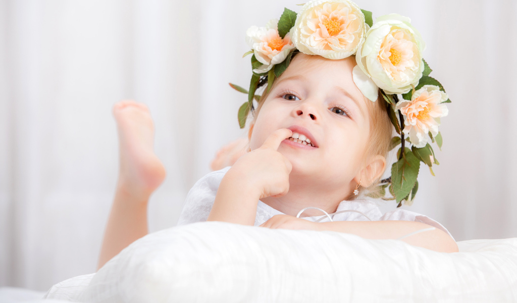 Маленькая девочка с красивым венком из цветов на голове