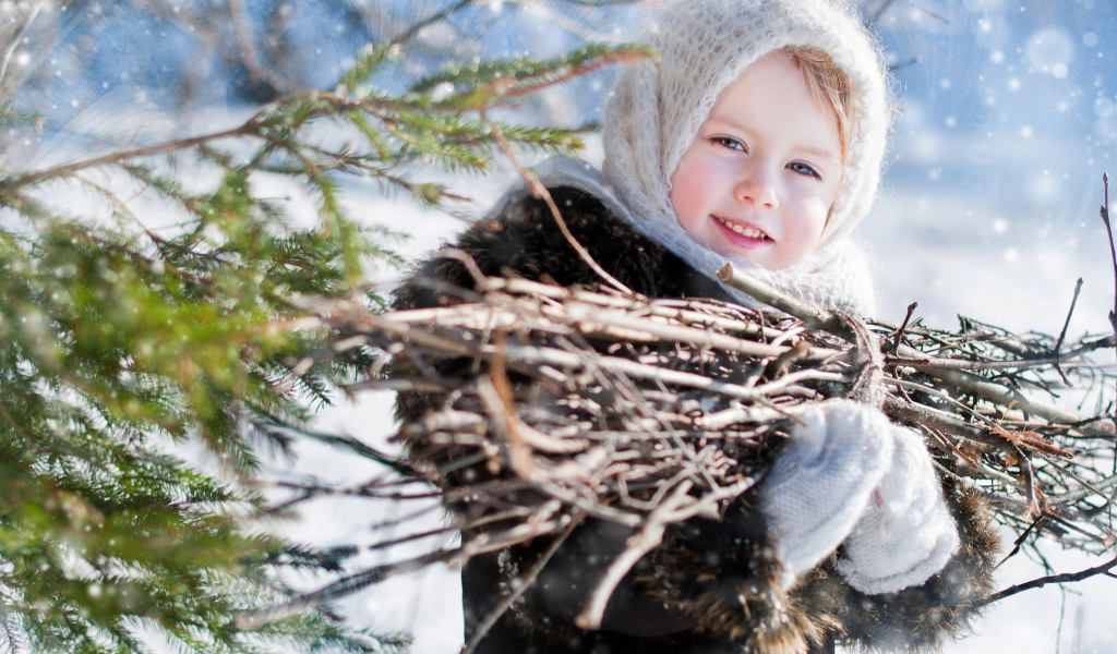 Маленькая девочка с пучком хвороста зимой