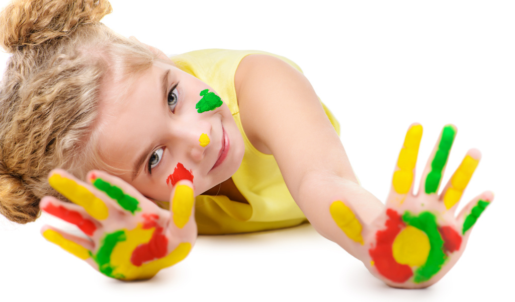 Маленькая девочка с руками в краске на белом фоне