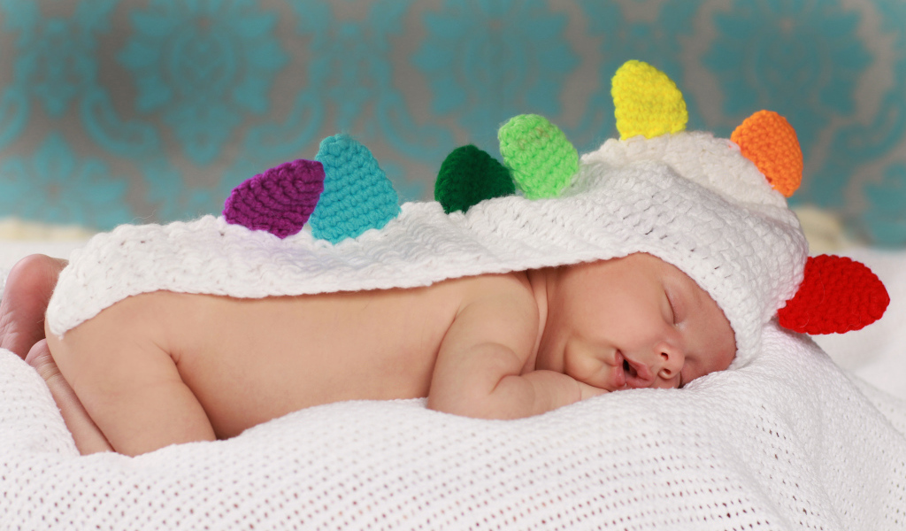 Спящий младенец в белой вязаной накидке