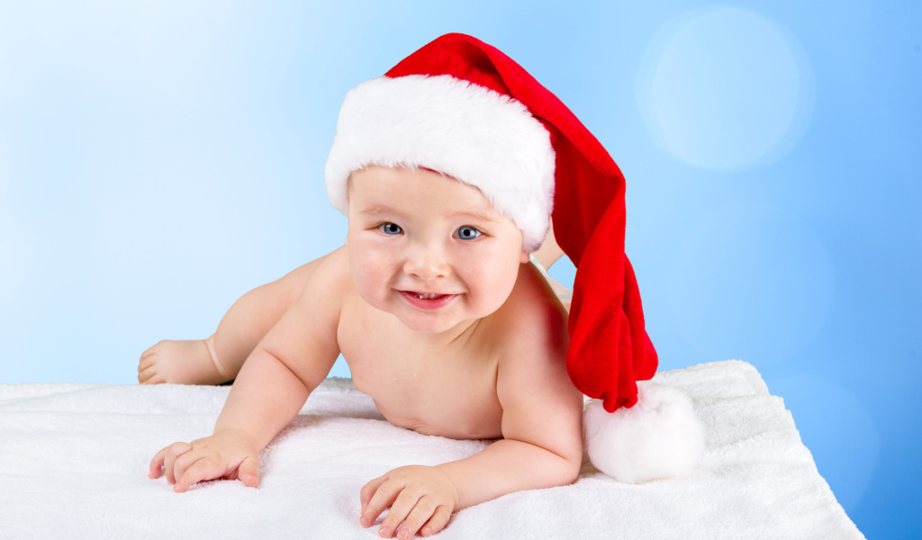 Улыбающийся грудной ребенок в новогодней шапке