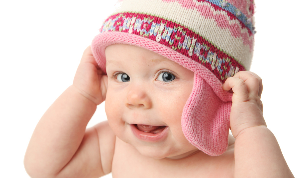 Улыбающийся ребенок в шапке на белом фоне