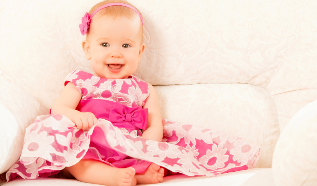 Улыбающаяся маленькая девочка в красивом розовом платье