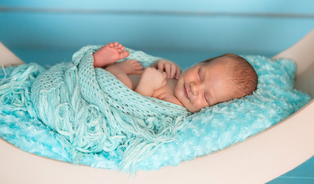 Грудной ребенок улыбается во сне