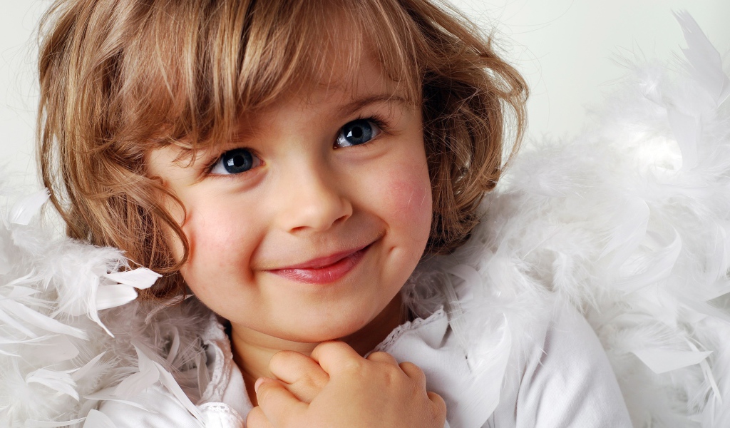 Маленькая голубоглазая девочка в костюме ангела 
