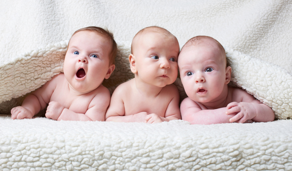Три младенца под белым теплым одеялом