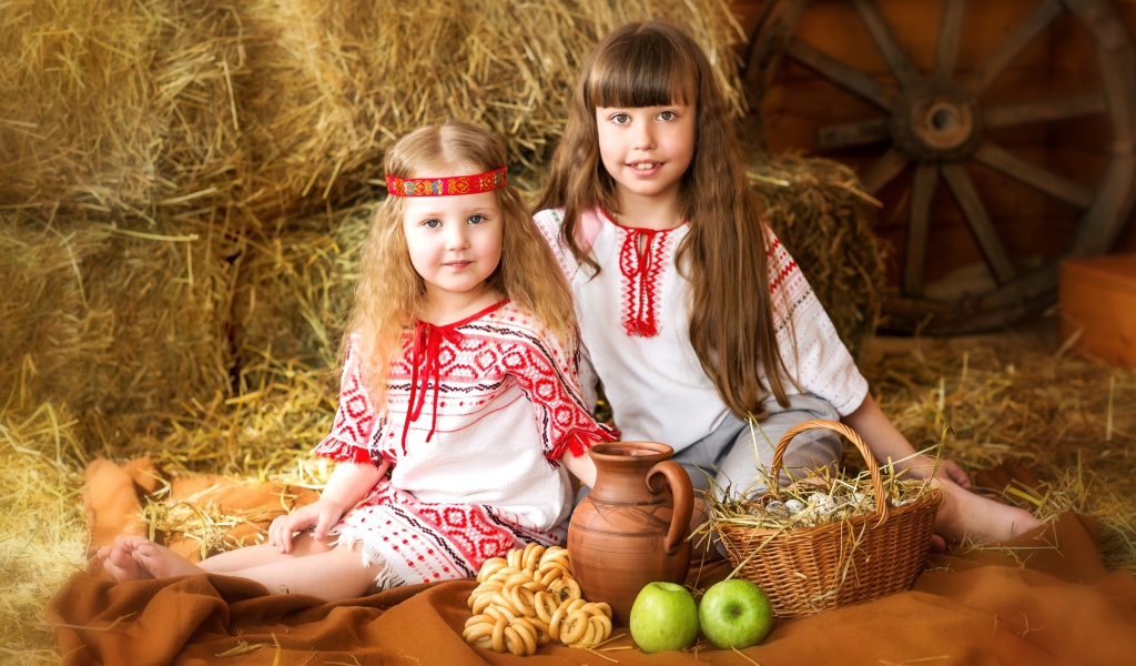 Две маленькие девочки в красивых костюмах с угощениями