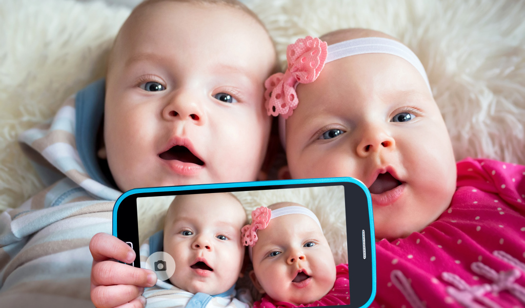 Два маленьких ребенка делают селфи на телефон